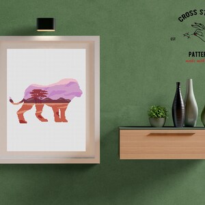 May include: A framed cross stitch pattern of a lion with a landscape inside its silhouette. The pattern is titled "Cross Stitch Pattern made with love" and includes the text "EST 2020".
