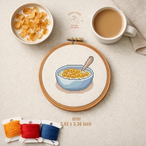 Puede incluir: Un bastidor de bordado de punto de cruz con un diseño de tazón de cereal con una cuchara. La imagen incluye un tazón de cereal con leche, una taza de café y carretes de hilo. El texto dice "CROSS STITCH PATTERN made with love" y "mini 8.71cm x 8.53cm".