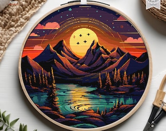 Può includere: Schema di punto croce di un paesaggio montano pixelato con un grande sole giallo e un lago in primo piano. Il cielo è blu scuro con stelle e un arcobaleno.