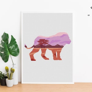 May include: Cross stitch pattern of a lion silhouette with a sunset landscape inside. The lion is facing right and the landscape is a purple and orange sunset with trees.