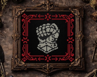 Pode incluir: Um padrão de ponto cruz emoldurado com um desenho de caveira. A caveira é branca e cinza sobre um fundo preto, emoldurada por uma borda vermelha. A moldura é ornamentada com um acabamento escuro e antigo. O texto "CROSS STITCH PATTERN" está na parte inferior.