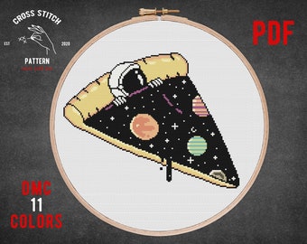 May include: A cross stitch pattern featuring a slice of pizza with a space-themed design. The pizza crust is yellow, the filling is black with stars, planets, and an astronaut. The pattern is in a wooden embroidery hoop. The text "PDF" is in the top right corner. The text "DMC 11 COLORS" is in the bottom left corner.