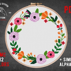 May include: A cross stitch pattern featuring a floral wreath with pink, orange, red, and green flowers. The pattern includes a simple alphabet and is available in 12 colors. The pattern is in a PDF format.