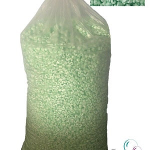 Puede incluir: Una gran bolsa de plástico transparente llena de cacahuetes de embalaje verdes. Los cacahuetes tienen forma de letra "S".