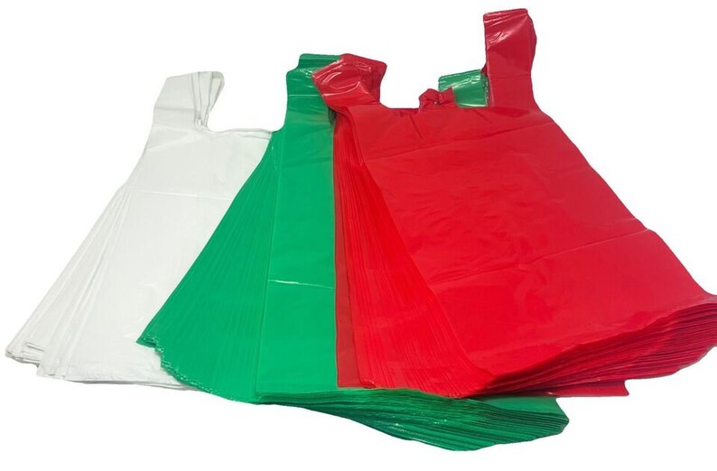 May include: A stack of plastic bags in white, green, and red. The bags are folded and stacked on top of each other.