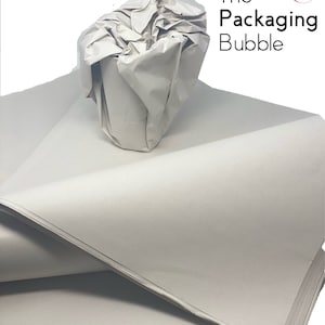 May include: A stack of white tissue paper, crumpled and folded, with a white cup in the center. The tissue paper is used for packing and protecting fragile items.