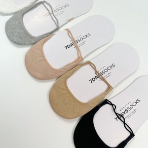 May include: Five pairs of no-show socks in different colors: white, gray, beige, brown, and black. The socks are made of a soft, stretchy material and have a delicate lace detail at the ankle. The socks are packaged on white cards with the brand name "7DAYSSOCKS" printed on them.