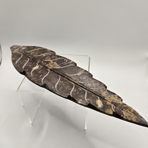May include: A brown marble leaf incense burner with a carved design. The leaf is about 12 inches long and 3 inches wide.