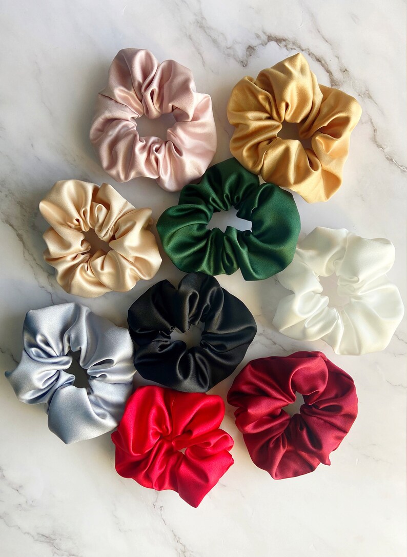 May include: Assortment of ten colorful satin scrunchies in various colors including red, green, black, white, gold, and light blue.