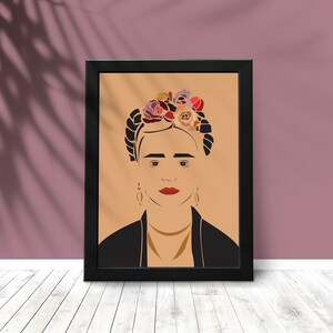 May include: A framed print of a stylised portrait of Frida Kahlo with a floral crown. The background is a light brown colour and the frame is black.