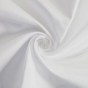 Könnte beinhalten: Nahaufnahme eines weißen Stoffes, der in einer Spirale angeordnet ist. Der Stoff hat eine glatte, seidige Textur mit sanften Falten und Lichtreflexen. Das Bild vermittelt ein Gefühl von Weichheit und Eleganz.