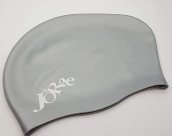 May include: A gray silicone swim cap with the word "Jorae" printed in white on the side.