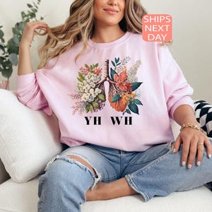 May include: A pink sweatshirt with a floral print of a human lung and the text "YIH WH".