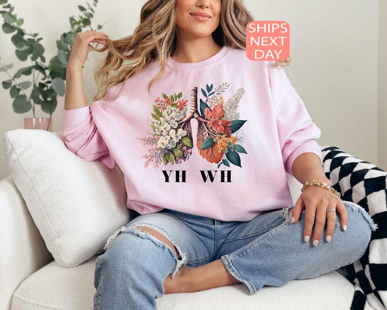 May include: A pink sweatshirt with a floral print of a human lung and the text "YIH WH".