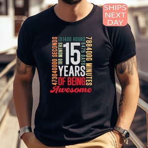May include: Black t-shirt with a colorful graphic design that reads "15 Years of Being Awesome" and includes the number of seconds, minutes, hours, days, months, and years in 15 years.
