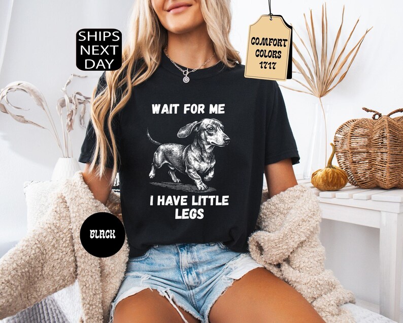 May include: Black t-shirt with a dachshund illustration and the text "WAIT FOR ME I HAVE LITTLE LEGS". The shirt also has the text "BLACK" and a tag that says "COMFORT COLORS 1717".