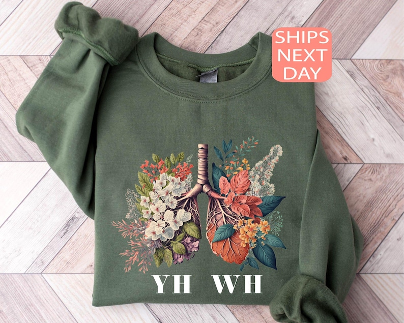 May include: Green sweatshirt with a floral print of a pair of lungs and the text "YH WH".
