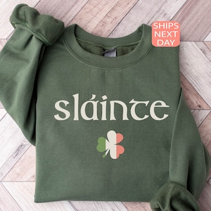May include: Green sweatshirt with the Irish word "sl&aacute;inte" printed in white and a shamrock with the Irish flag colors.