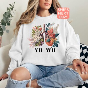 May include: White sweatshirt with a floral design of lungs and the text "YH WH" printed on the front.
