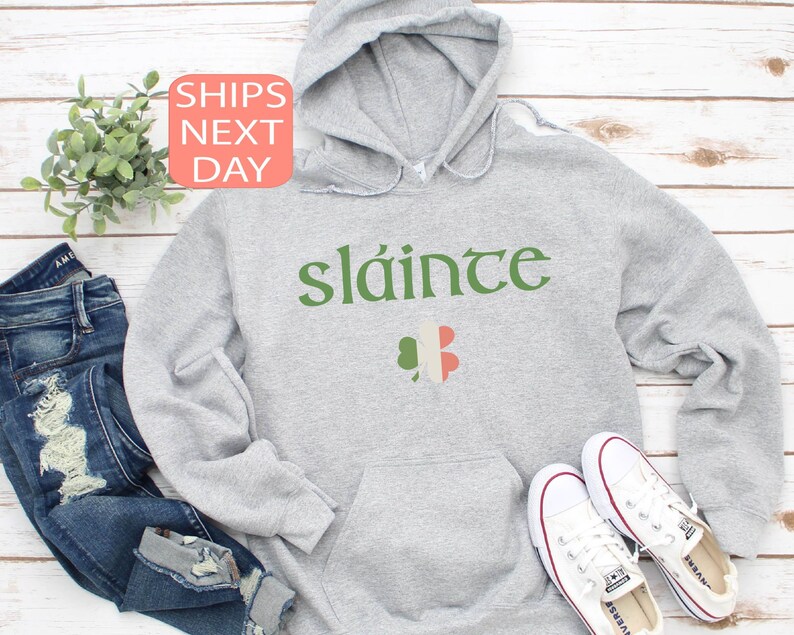 May include: Gray hooded sweatshirt with the Irish phrase "sl&aacute;inte" in green lettering and a shamrock with the Irish flag colors.