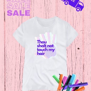 Puede incluir: Camiseta blanca con un estampado de mano morado y el texto "Thou shalt not touch my hair".