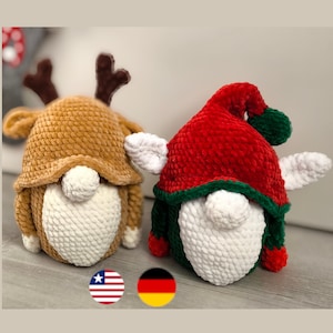 Könnte beinhalten: Zwei gehäkelte Gnome, einer mit einem braunen Rentierhut und der andere mit einer roten und grünen Elfenmütze. Beide Gnome haben weiße Gesichter und sind aus weichem, strukturiertem Garn gefertigt.