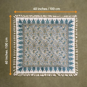May include: Square white and blue paisley patterned textile, 40 inches (100 cm) on each side, with a fringed edge. The textile features a repeating paisley design in shades of blue and gold on a white background. The border is a darker blue with a geometric pattern.