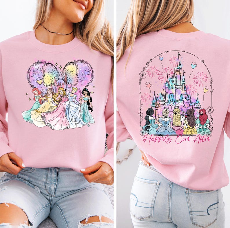 Puede incluir: Sudadera rosa con un dise&ntilde;o de acuarela de princesas Disney delante de un lazo y un castillo con fuegos artificiales en la espalda. El texto "Happily Ever After" est&aacute; impreso en la espalda.