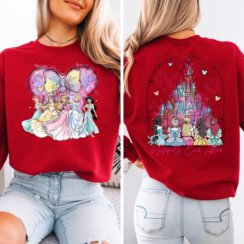 Puede incluir: Sudadera roja con una ilustraci&oacute;n de acuarela de las princesas de Disney frente a un lazo de Mickey Mouse en la parte delantera y una ilustraci&oacute;n de acuarela del castillo de Cenicienta con fuegos artificiales y el texto "Happily Ever After" en la parte posterior.