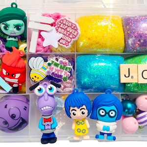 May include: A clear plastic organizer filled with colorful slime and character figurines. The organizer contains yellow, blue, and purple glitter slime, along with figurines of characters from the movie "Inside Out". Decorative elements include wooden letter tiles spelling "JOY".