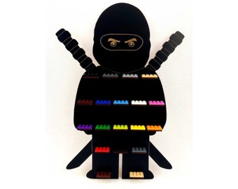 May include: Black silhouette of a ninja holding two swords with a display of 18 colorful Lego bricks.