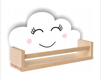 May include: A white wooden shelf shaped like a smiling cloud with pink cheeks. The shelf has a single wooden shelf for displaying small items.