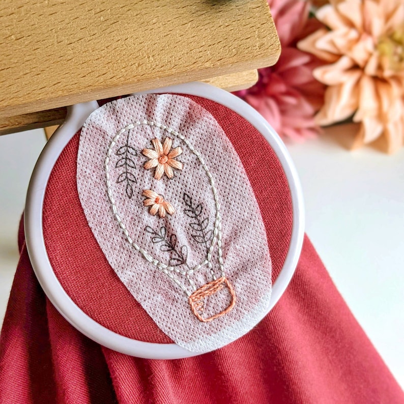 Example of adventure stick and stitch designs in use. Hot air balloon patch with floral petal and leaf details. Soft pastel colours. Just stick on and start embroidering straight away. Perfect summer and Spring project. Make memories and stitch them