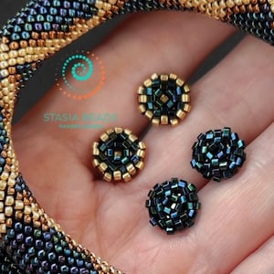 May include: A gold and black beaded snake necklace with a snake head clasp. The necklace is paired with matching earrings.