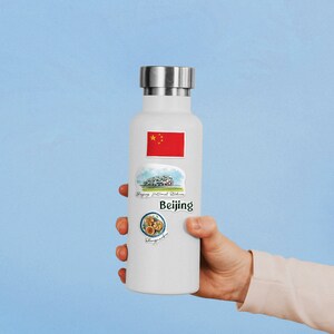 May include: White insulated water bottle with stickers featuring the Chinese flag, the Beijing National Stadium, and the text "Beijing" and "Peking Duck".