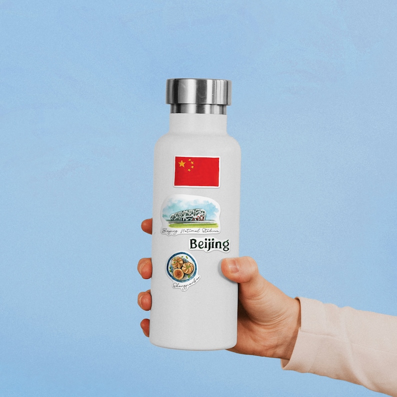 May include: White insulated water bottle with stickers featuring the Chinese flag, the Beijing National Stadium, and the text "Beijing" and "Peking Duck".