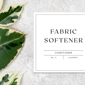 May include: White square label with black text that reads "FABRIC SOFTENER" with the words "CONDITIONER" and "LAUNDRY" below. The label is on a white background with green and white leaves.