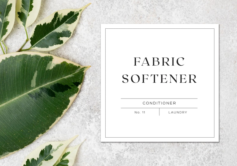 May include: White square label with black text that reads "FABRIC SOFTENER" with the words "CONDITIONER" and "LAUNDRY" below. The label is on a white background with green and white leaves.