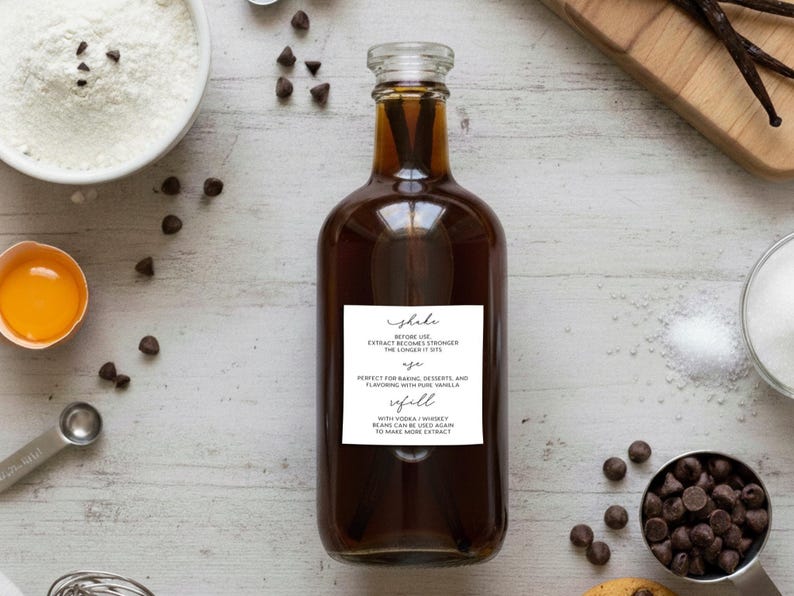 May include: A clear glass bottle filled with dark brown vanilla extract, featuring a white rectangular label with black text that reads: Shake before use. Extract becomes stronger the longer it sits. Age. Perfect for baking, desserts, and flavoring with pure vanilla. Refill. With vodka / whiskey beans can be used again to make more extract.