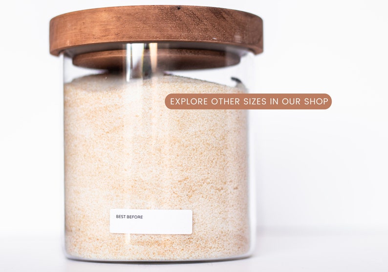 May include: A glass jar with a wooden lid filled with white grains. The jar has a label that says "BEST BEFORE" and a sticker that says "EXPLORE OTHER SIZES IN OUR SHOP".