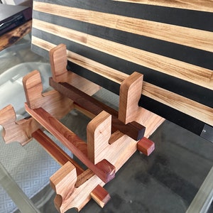 May include: A wooden stand with a distressed American flag design. The stand is made of multiple types of wood, including cedar and walnut. The flag is displayed on the stand, with the stars and stripes visible.