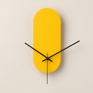 May include: A bright yellow wall clock with a pill-shaped, elongated oval face. The clock features three thin, black metal hands positioned at the center, including an hour hand, a minute hand, and a second hand, set against a solid yellow background.
