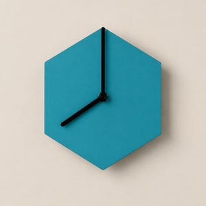 Könnte beinhalten: Eine sechseckige Wanduhr mit einem einfarbigen, blaugrünen Zifferblatt und zwei dünnen schwarzen Zeigern. Die Uhr hat ein schlichtes, geometrisches Design ohne Zahlen oder Stundenmarkierungen auf der Oberfläche. Die Zeiger zeigen die Uhrzeit an.