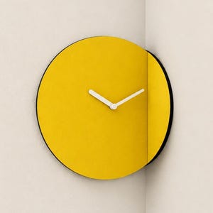May include: A circular wall clock with a bright yellow face and a black outer edge. The clock features two white hands and is mounted directly into a corner, with one portion of the clock face angled along the adjacent wall surface.