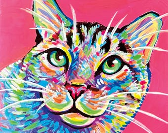 May include: A vibrant painting of a cat head against a solid pink background. The cat features expressive green eyes and a pink nose, rendered with thick, multi-colored brushstrokes in shades of blue, yellow, orange, and white, with long white whiskers.