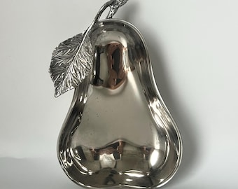 May include: A silver pear-shaped dish with a leaf detail on the stem. The dish is made of metal and has a shiny finish.