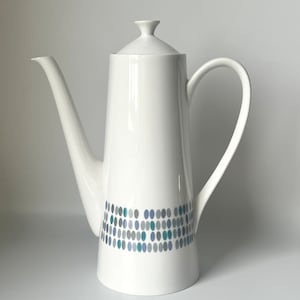 May include: White ceramic coffee pot with a blue and grey geometric pattern around the base.
