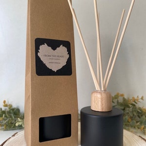 May include: A black diffuser bottle with wooden sticks and a brown cardboard box. The box has a window to show the diffuser bottle. The label on the box says "From the Heart" and "Sweet Vanilla".
