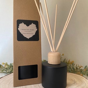 May include: Black diffuser bottle with a wooden lid and brown cardboard box. The box has a window to show the diffuser bottle. The diffuser sticks are made of natural wood. The label on the box says "From the Heart" and "Cuban Tobacco & Oak".
