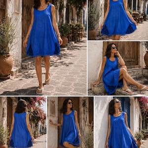 May include: A sleeveless royal blue mini dress featuring a scoop neckline and a loose, A-line silhouette. The hem is accented with dark blue lace panels and small pom-pom trim detailing along the bottom edge, creating a textured finish.